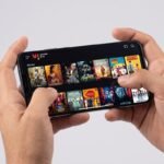 smartphone displaying the vi movies & tv app dashboard with bundled ott platforms.
